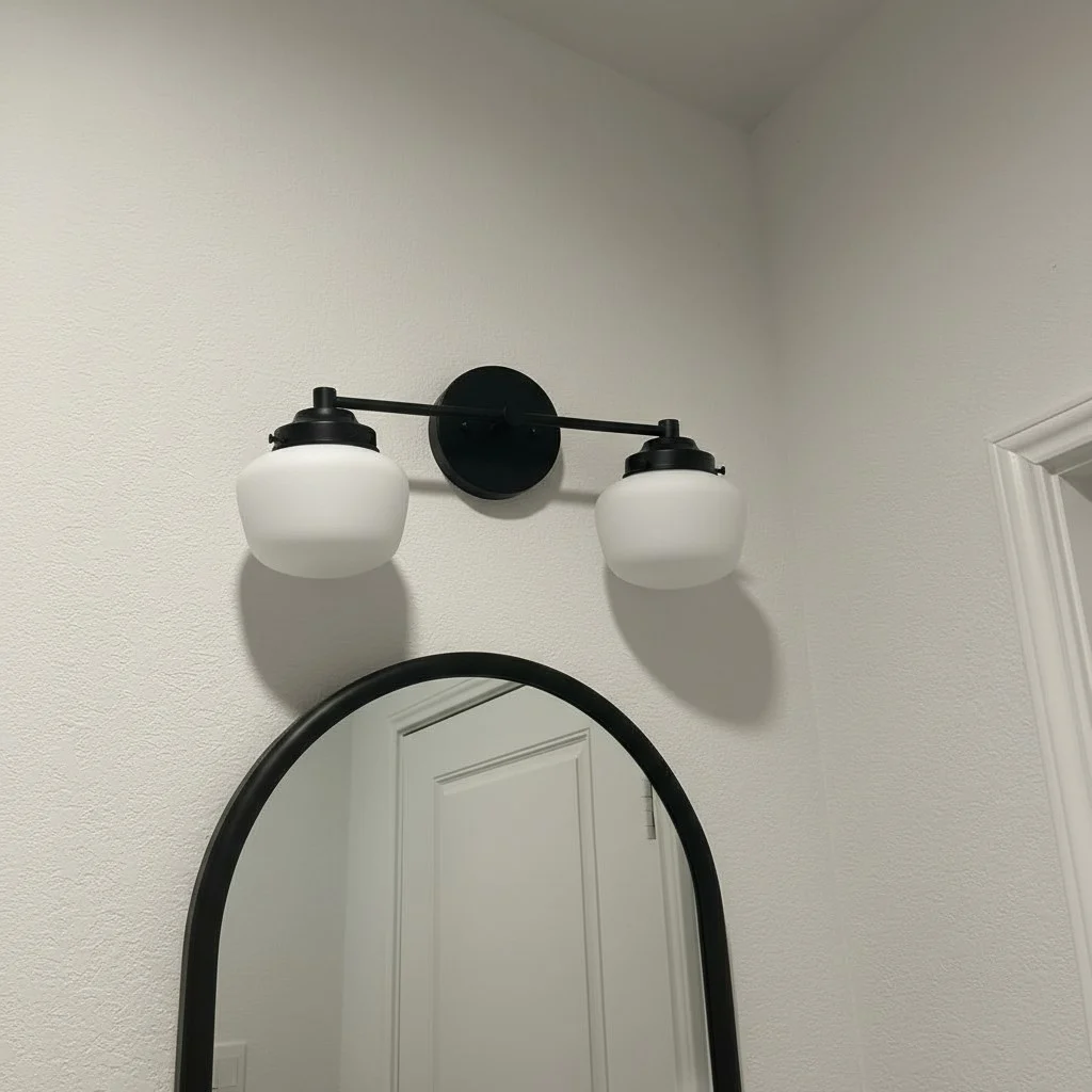 Customer photo of black Opalume wall sconce above round mirror