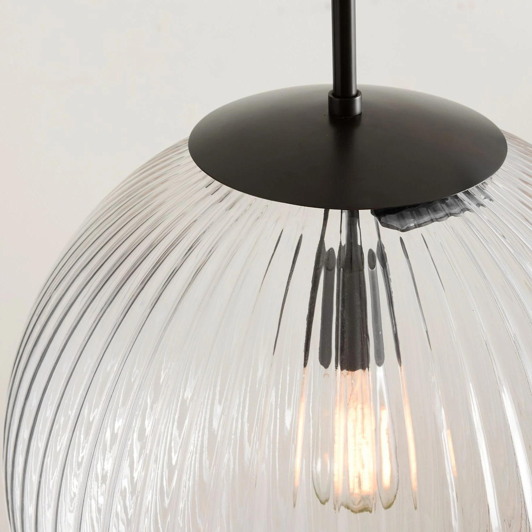 Close view of ribbed glass shade and black canopy