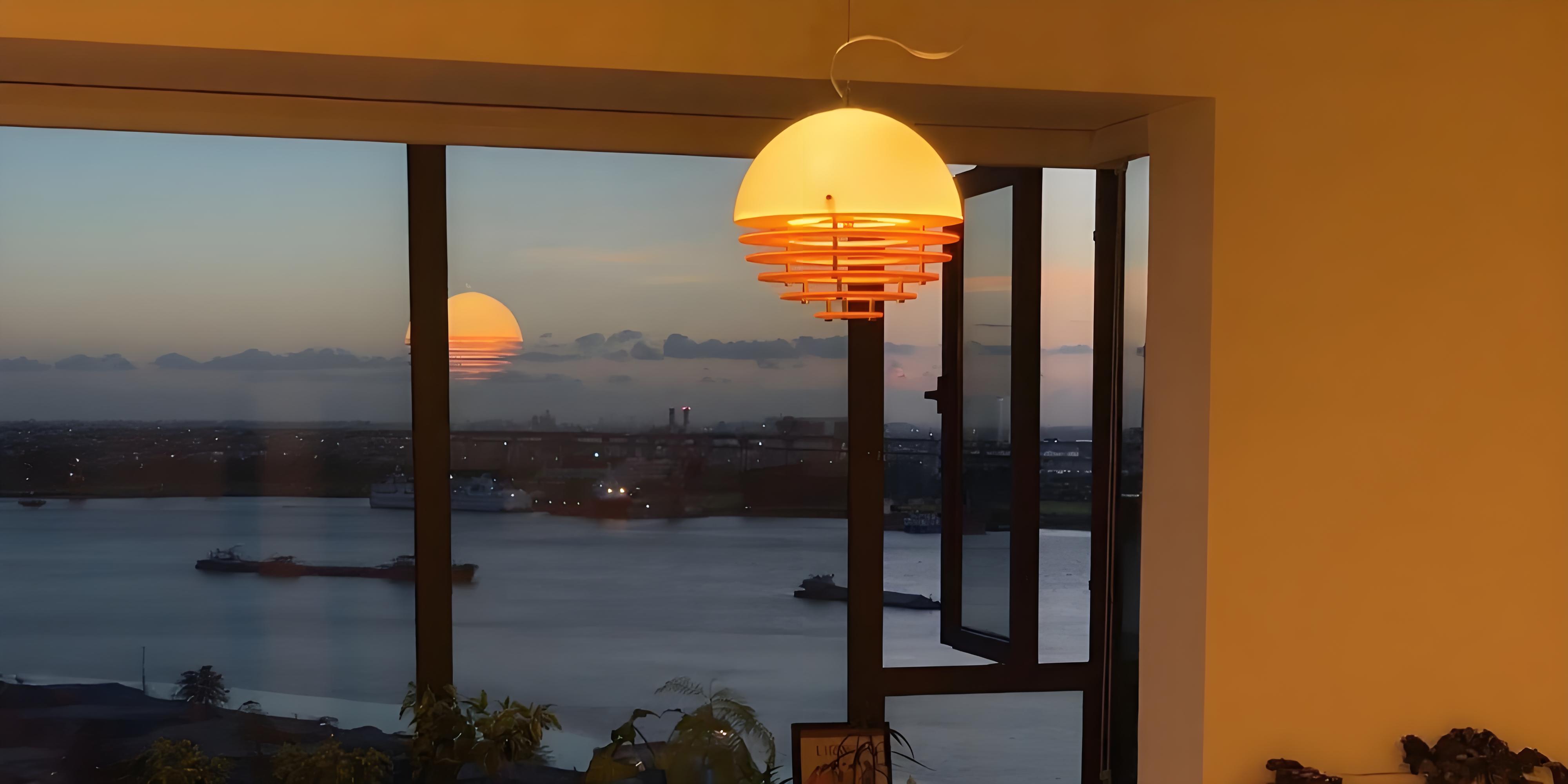 Afterglow sunset pendant lamp glowing by a window