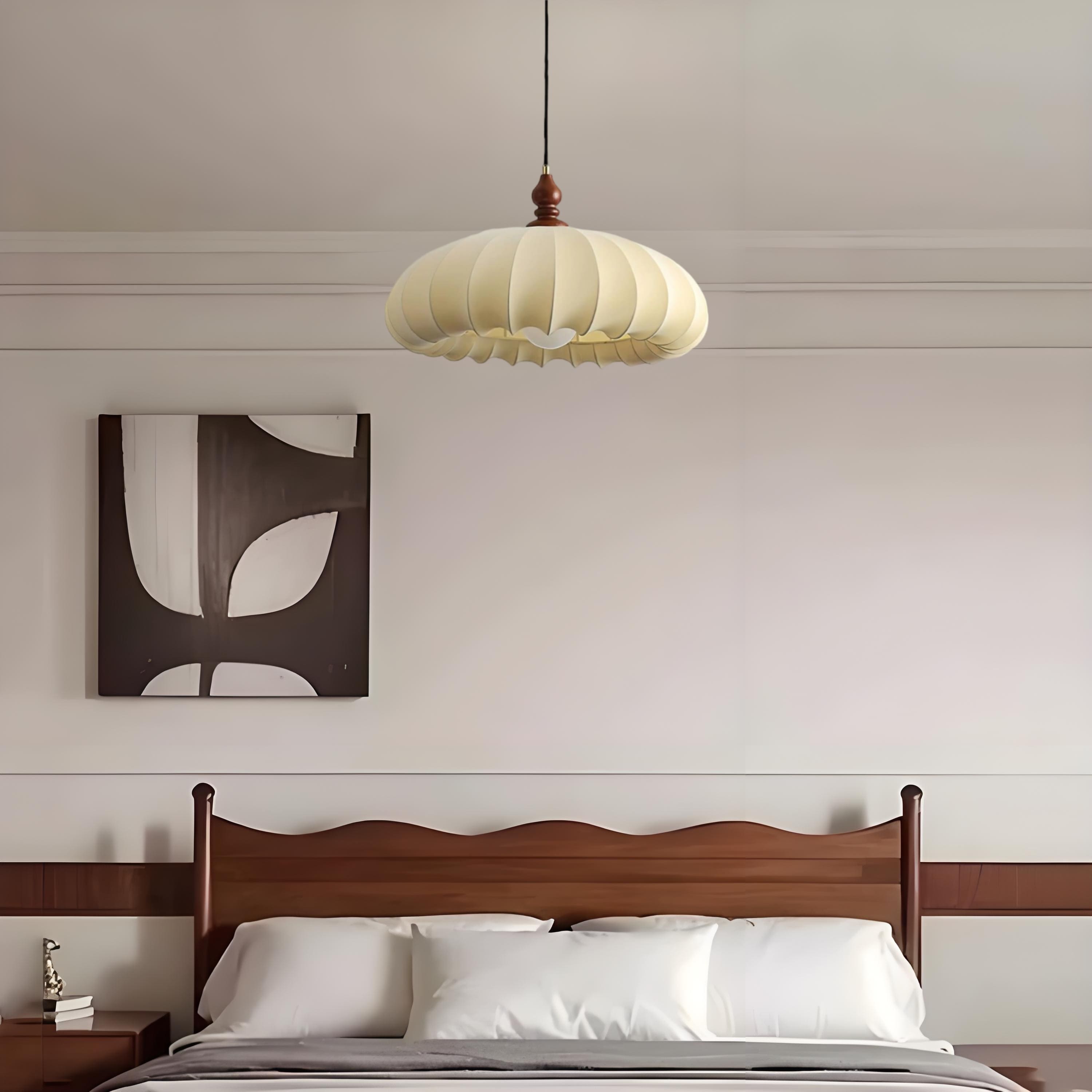Pleated fabric pendant lamp installed above a bed