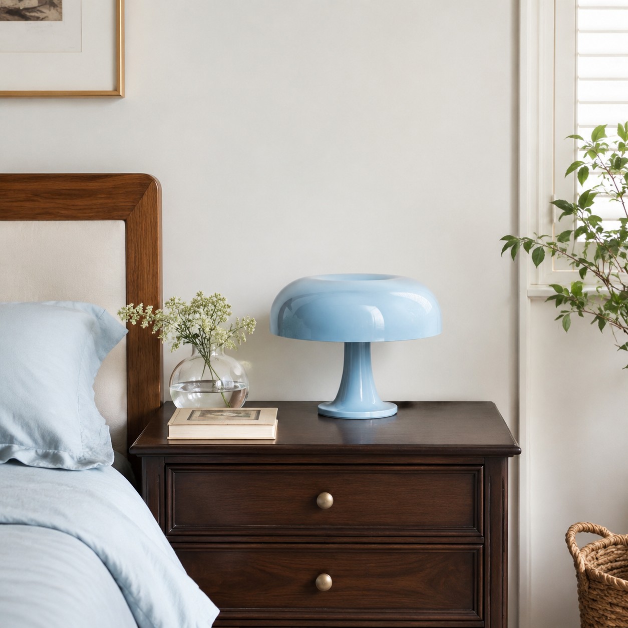 Blue mushroom table lamp on a dark bedside chest in a bright bedroom