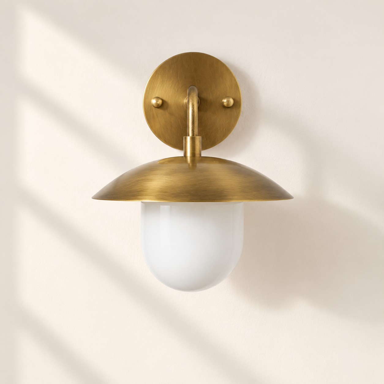 Brass-Finish Wall Sconce — Frosted White Glass Globe — An understated perspective