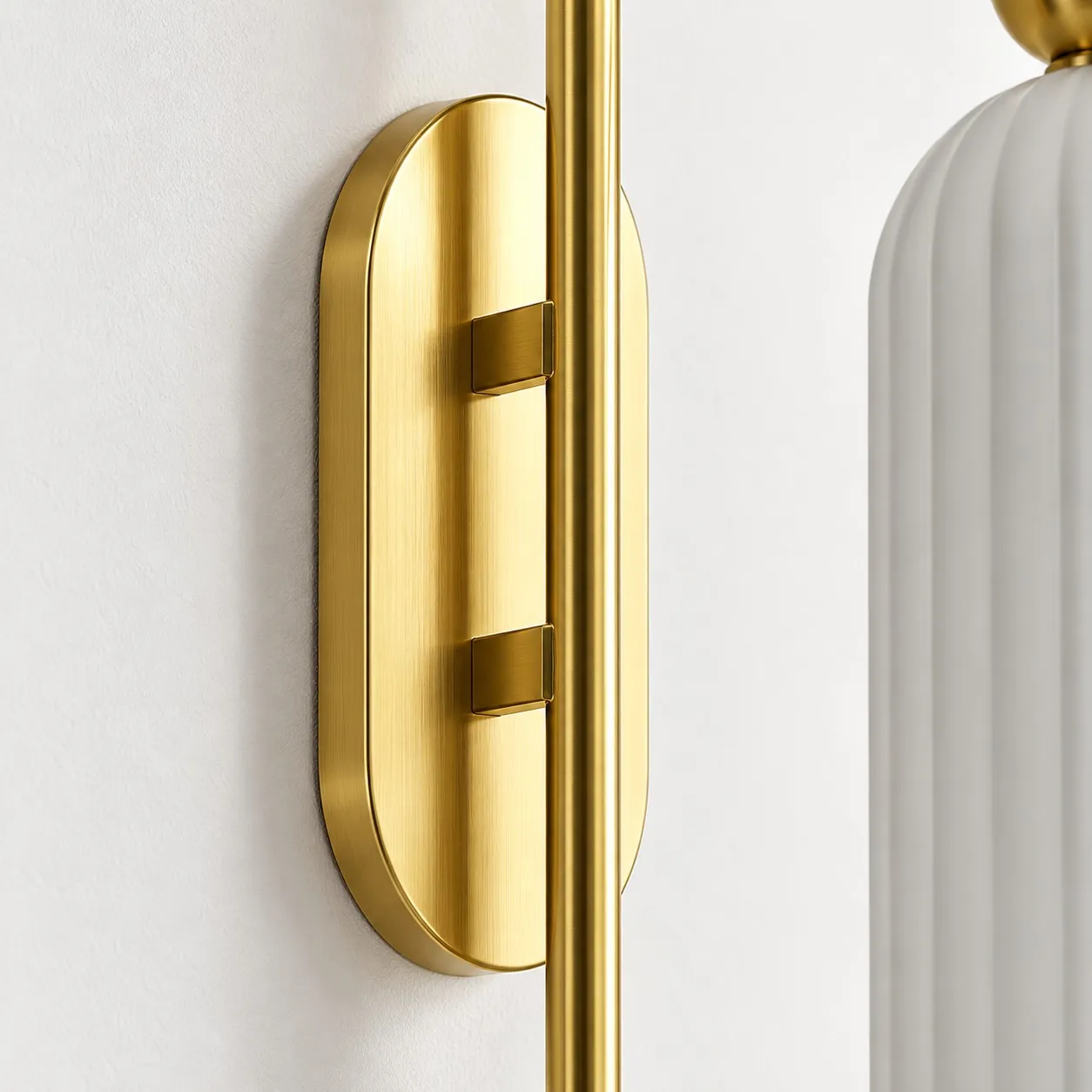 Brushed gold-tone oval backplate and slim vertical metal stem
