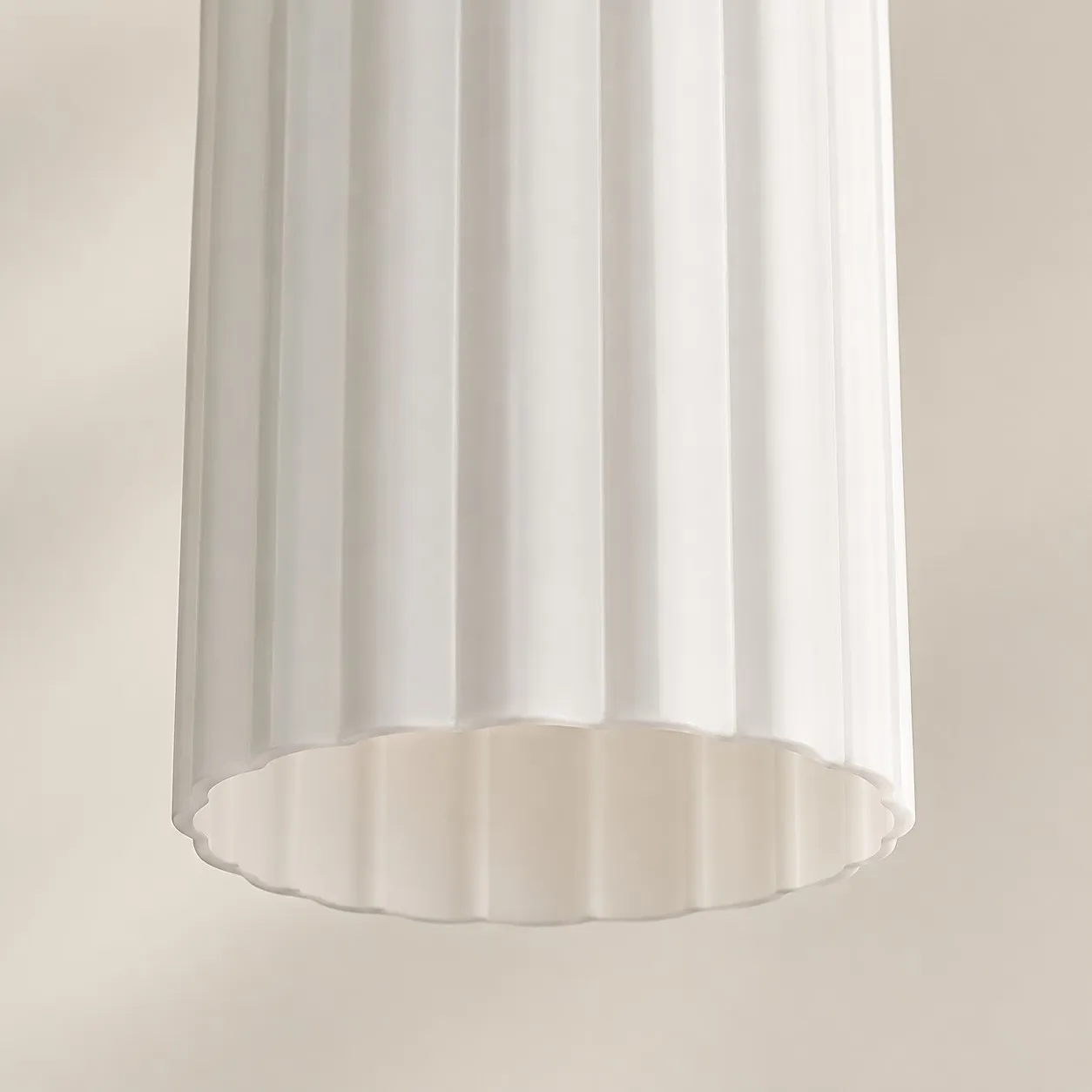 Close-up of the vertical fluting and open lower edge of the white glass shade