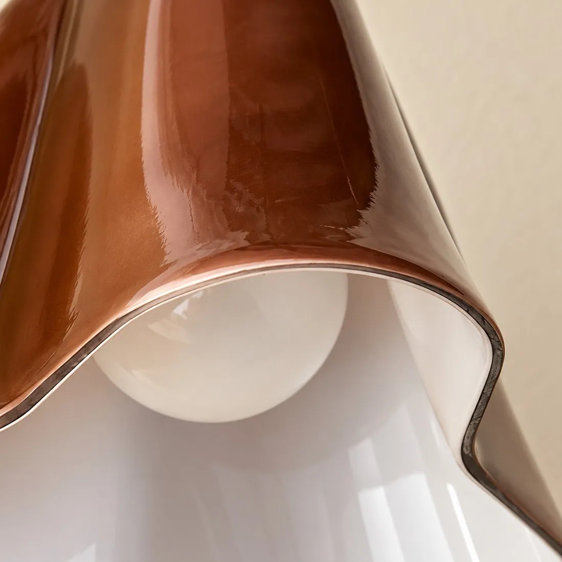 Close-up of the glossy Amber glass shade and its curved lower edge