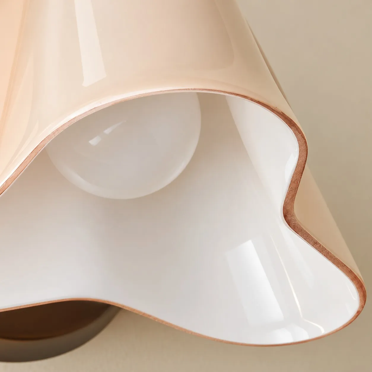 Close-up of the pale glass shade showing the flowing bell-shaped rim