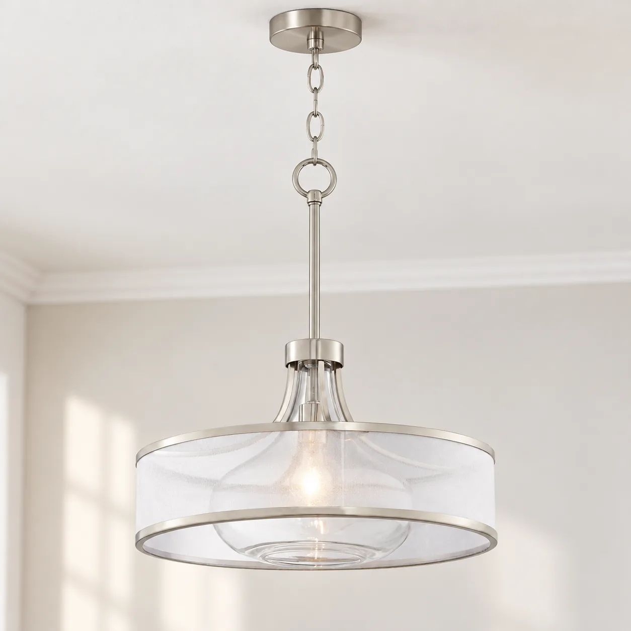Brushed nickel drum pendant mounted on a ceiling in daylight