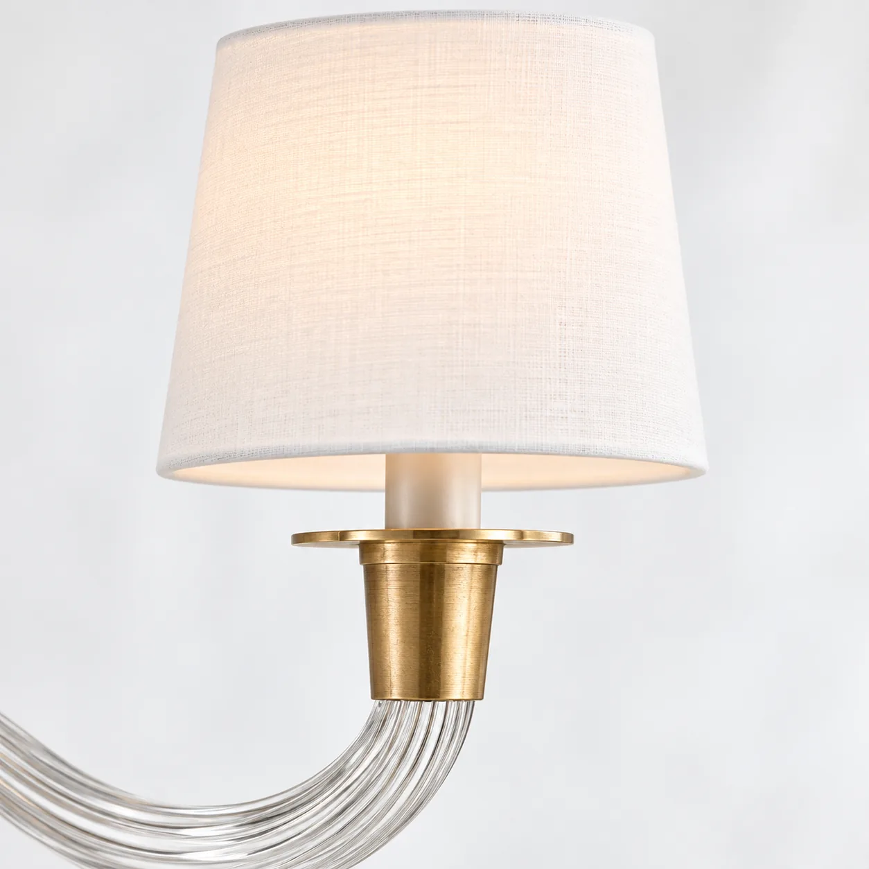 Close view of a white linen shade and brass candle cup